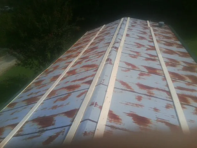 Rusted metal roof panels with new wood purlins before replacement — Storm Damage Roof Repair in Gurley by Roofing Brothers