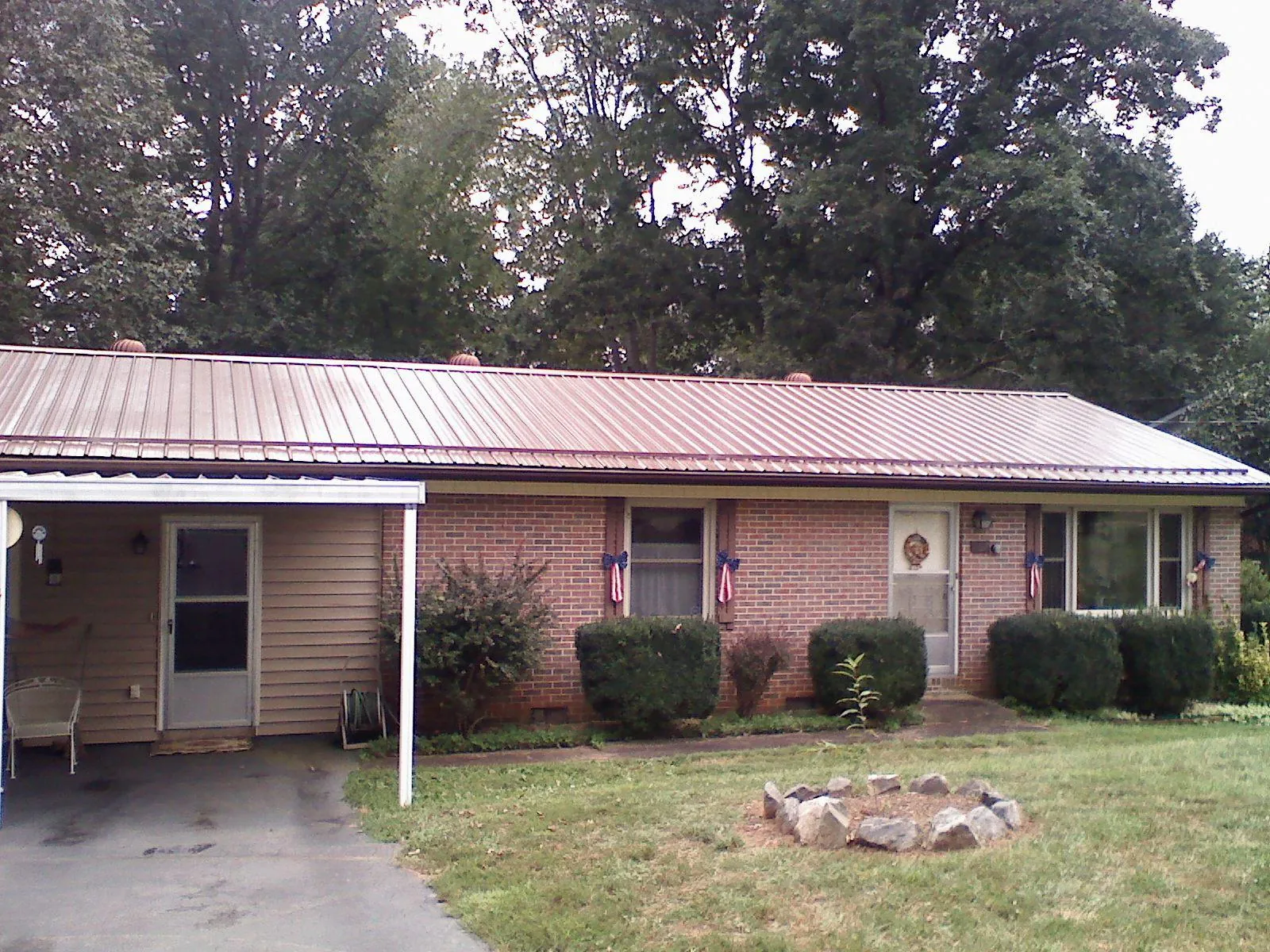 Bronze metal roof and carport on a brick ranch home — Roof Repair work by our crew in Gurley