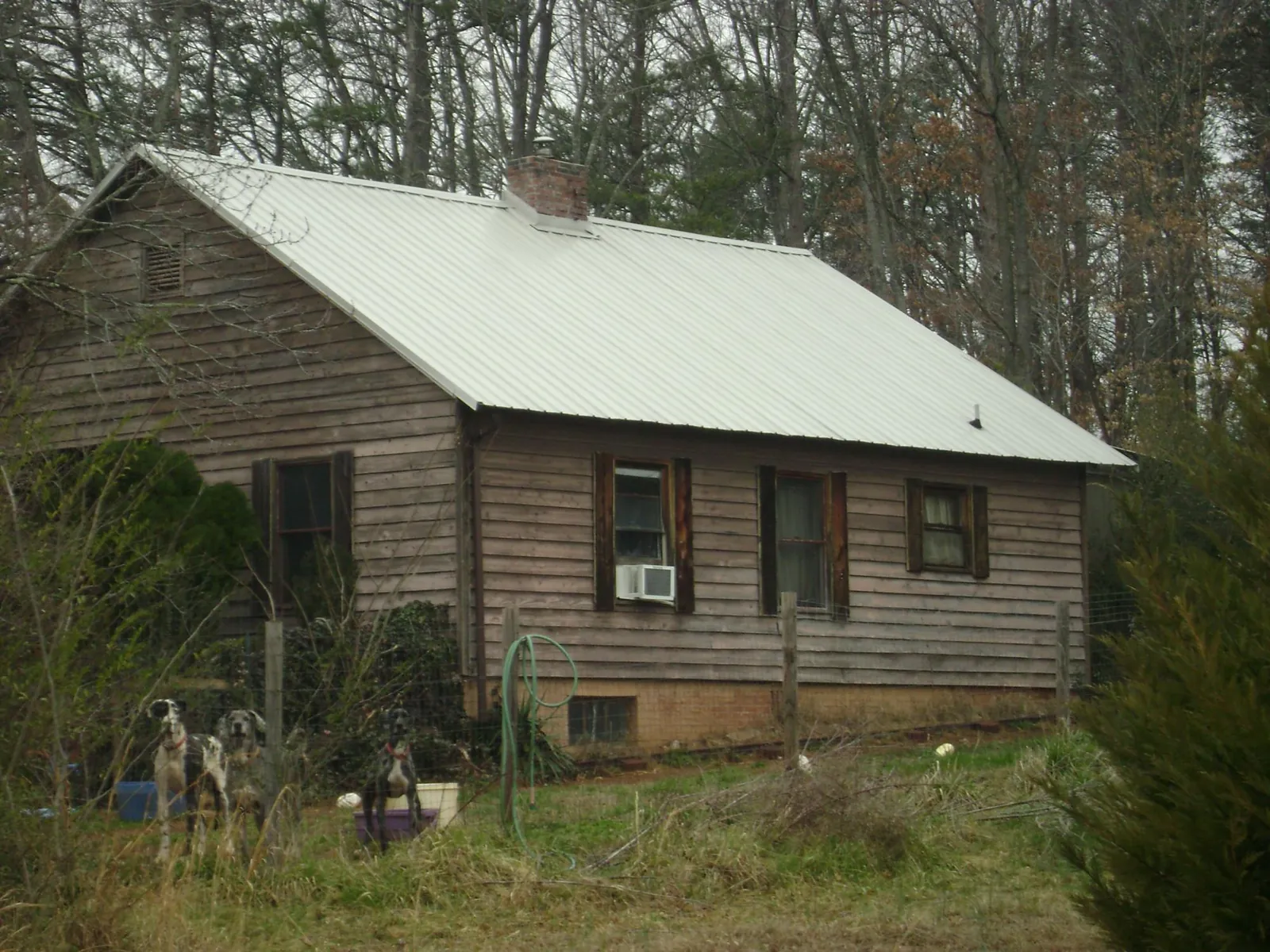White metal roof on an old wood sided farmhouse, from a Metal Roof Installation job in Gurley